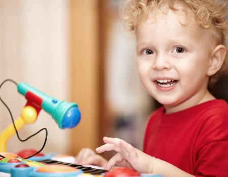 Adorable little boy playing with a toy microphone Kids and music